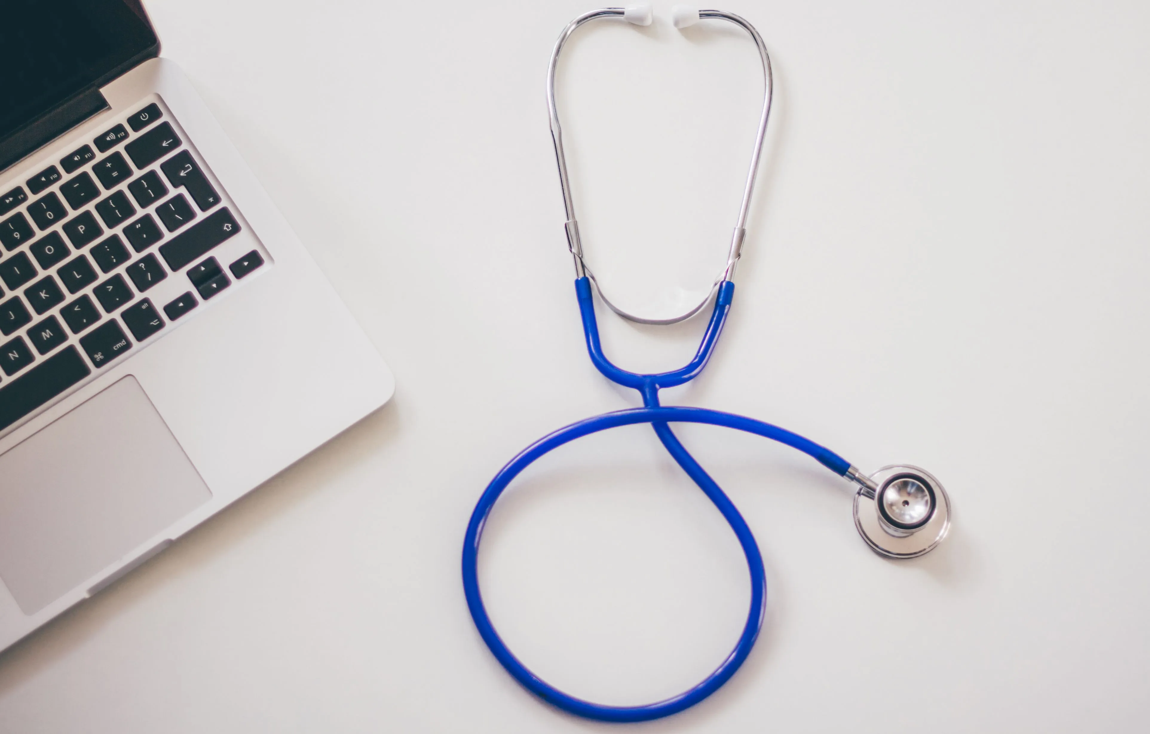 A stethoscope sits next to a laptop