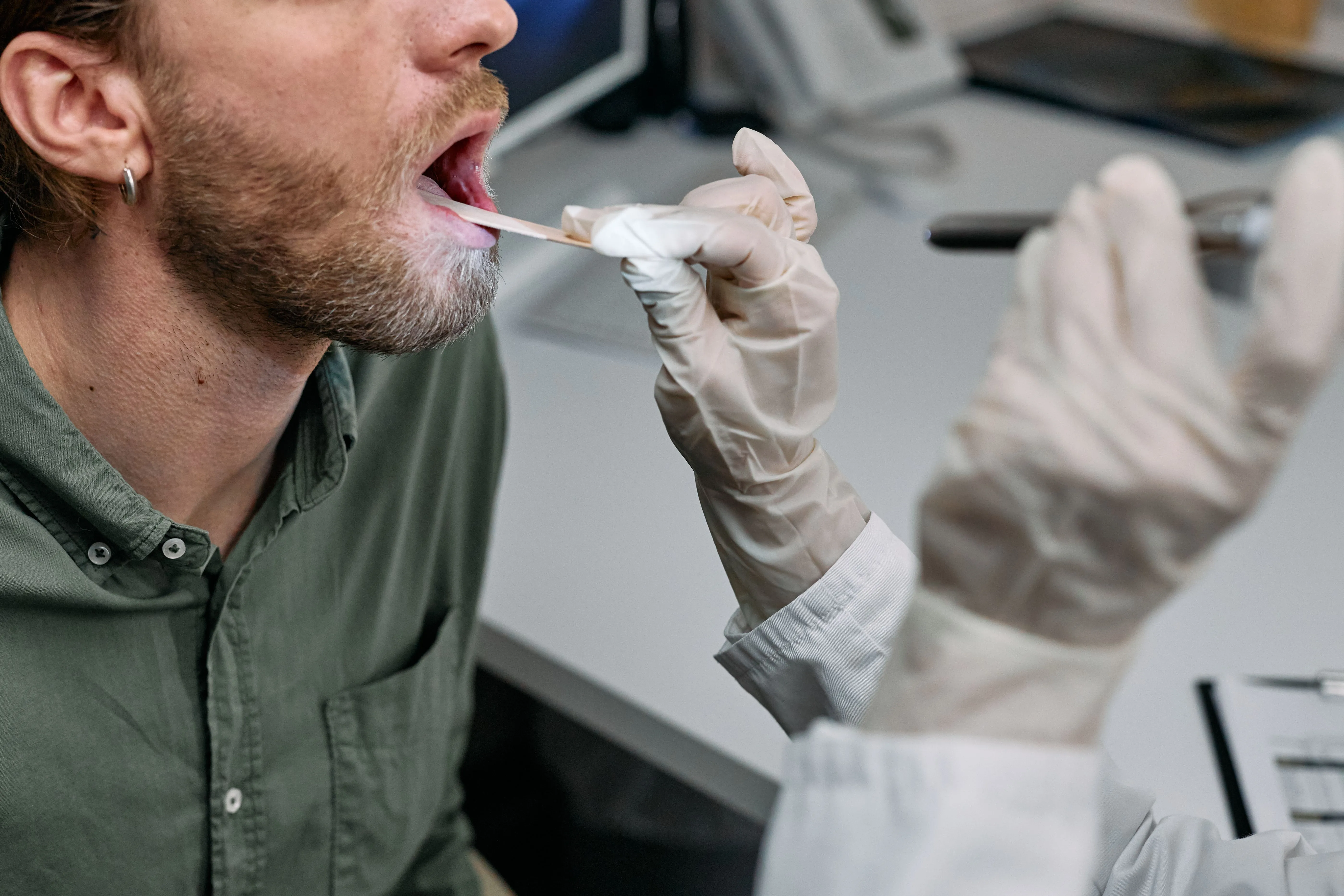 A doctor looks at a patient's tongue