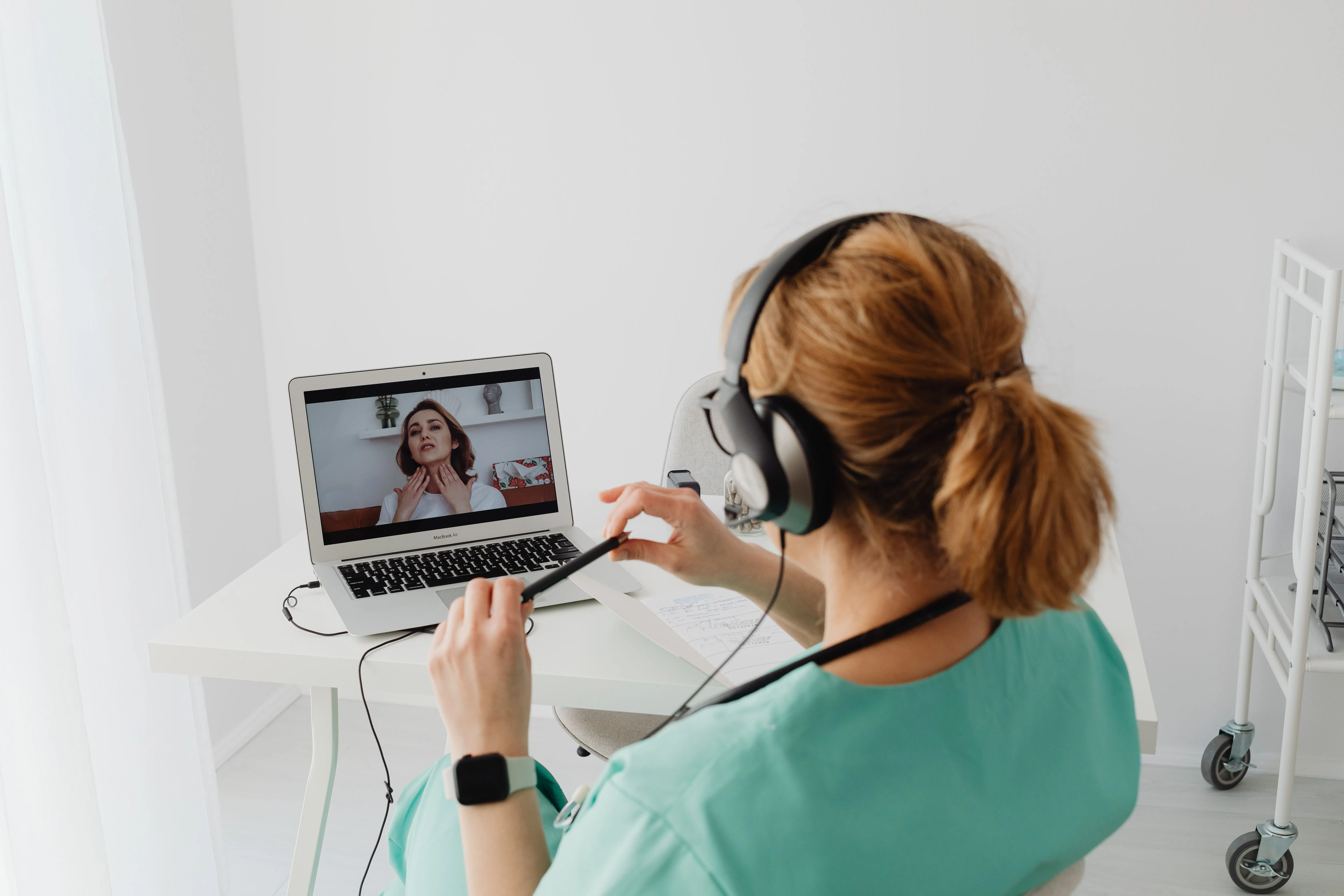 A doctor consults with a patient on a laptop.